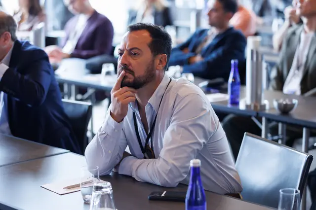 An attendee listening closely from the floor