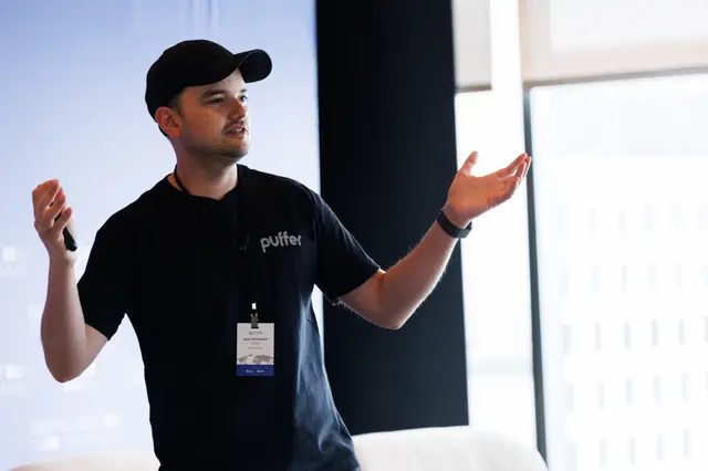 A speaker mid gesture in dramatic window light