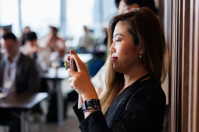 A guest catching the moment on her phone in warm light